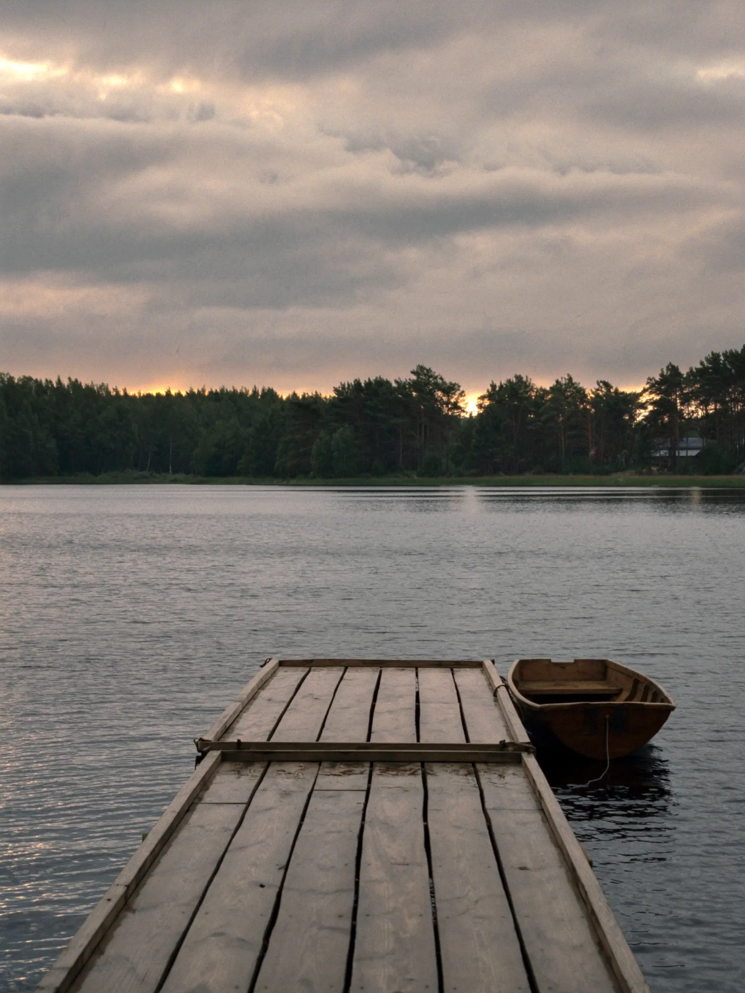 A wooden jetty on a calm northern lake in summer