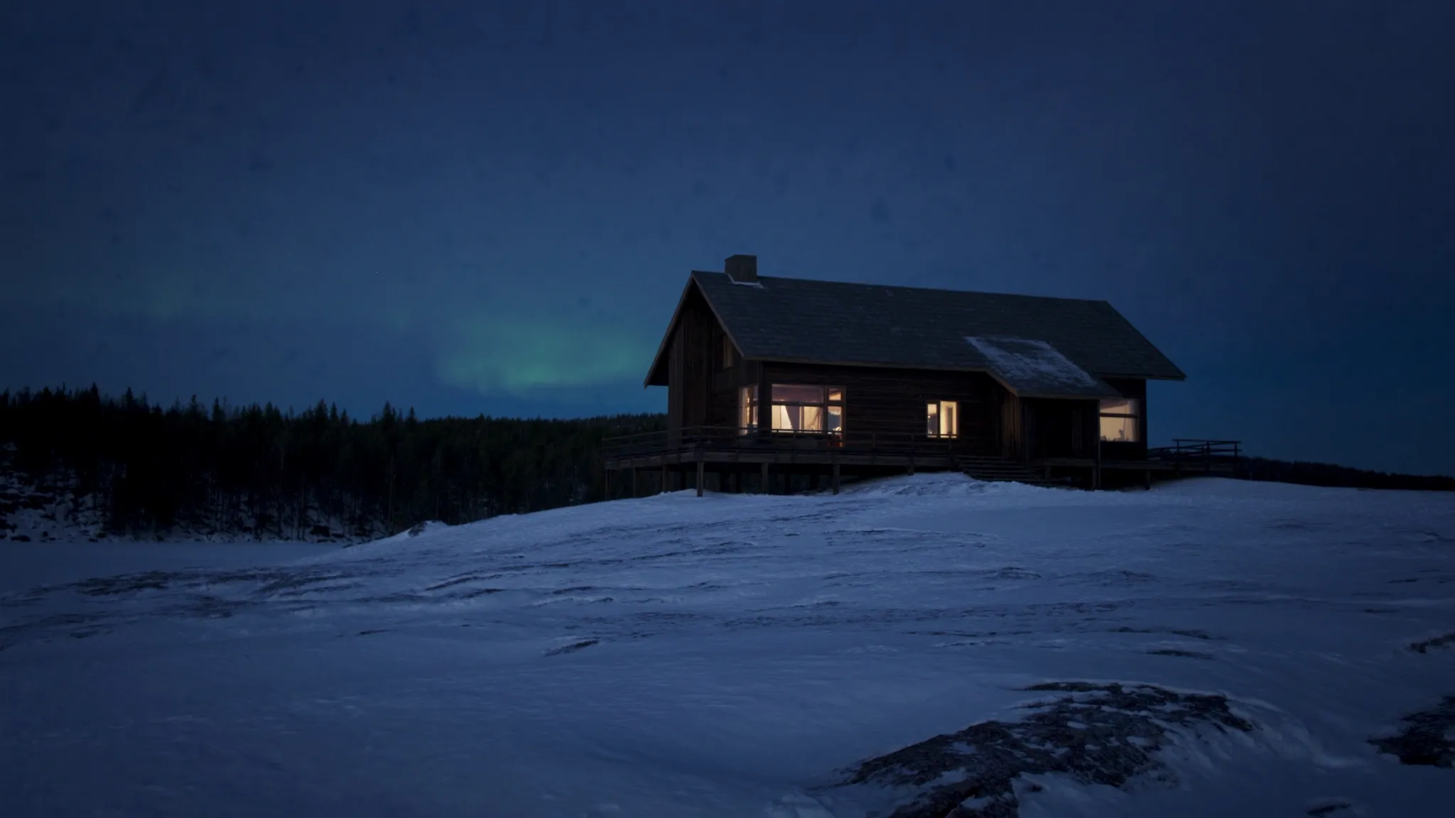 The lodge above the frozen lake under a faint aurora